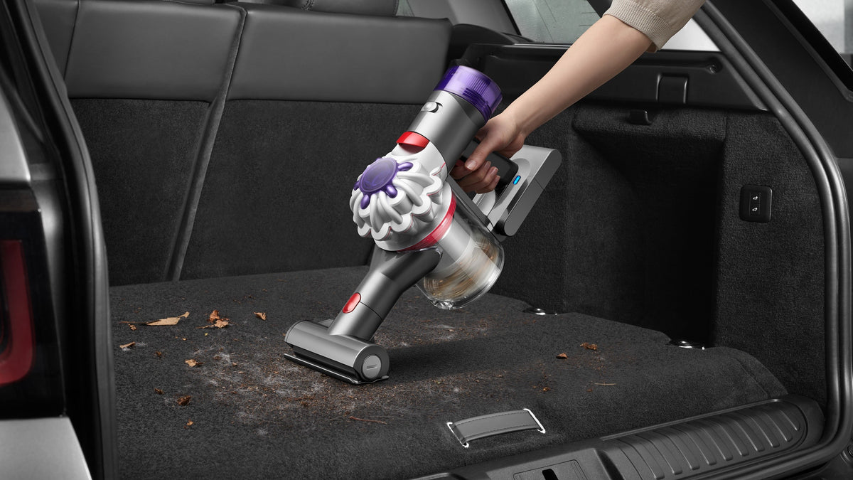 Le Dyson Car+Boat et sa mini brosse motorisée aspirent les feuilles et la terre dans le coffre d'une voiture