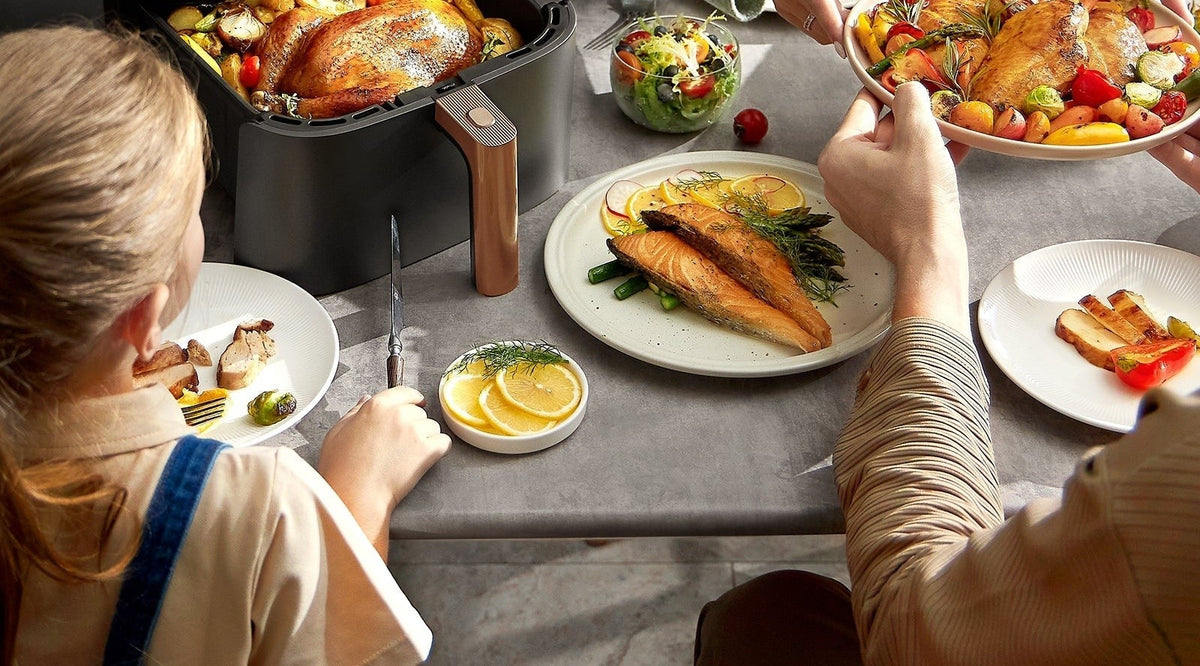 Poulet rôti et légumes dans le panier de 6 L de la Cosori TurboBlaze™ Chef Edition, servis en famille