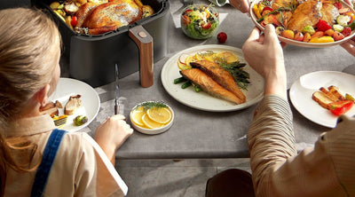 Poulet rôti et légumes dans le panier de 6 L de la Cosori TurboBlaze™ Chef Edition, servis en famille