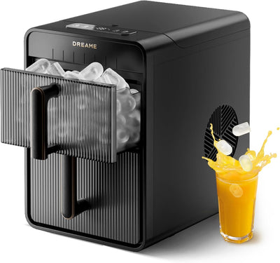 Machine à glaçons Dreame Aura Bullet IB-50 noire, panier à glaçons ouvert à côté d'un verre de jus d'orange