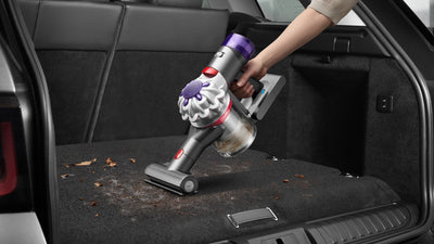 Le Dyson Car+Boat et sa mini brosse motorisée aspirent les feuilles et la terre dans le coffre d'une voiture